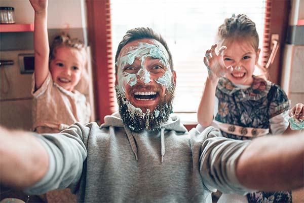 Father and daughters taking silly selfie